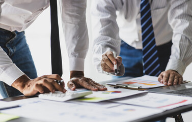 Businessman is calculating profit and analyzing financial data on report in office. Advisor is...
