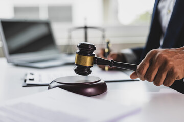 Lawyer holding gavel in courtroom making decision on legal case, symbolizing the legal profession and the pursuit of justice.