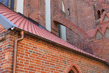 The sloping roof and walls of the red brick church