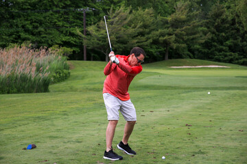 Golfer Swings Club on a Sunny Day at a Lush Green Golf Course