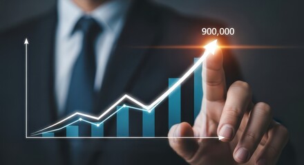 Photo of a businessmans hand points to an upward trending graph showing significant growth with the number 900000