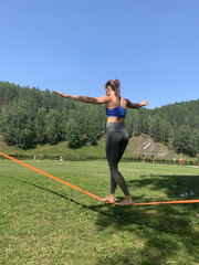 Woman Balancing on Slackline in Summer Nature