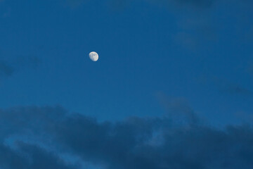 Evening sky with clouds and a faint glow of the moon in the distance. An atmosphere of introspection, tranquility, and self-discovery.