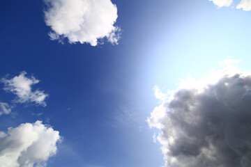 Bright sunlit sky with cumulus clouds and blue gradient captured on a clear spring day