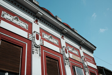 Close-up of ornate architectural details on a historic red and white building in Vrsac town, Serbia