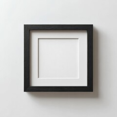 Minimalist square picture frame with black border and white matting mounted on clean white wall for modern home decor display