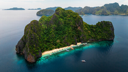 Wide Scenic Aerial Panorama of Bangka Boats Docked in Entalula Island’s Limestone Cliffs and Surrounding Islets in El Nido, Palawan, Philippines