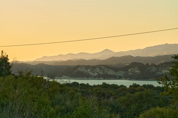Lake at Sunset with Reflections and Distant Hills
