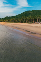 Stunning aerial view of Nacpan Beach’s winding shore, vibrant tropical greenery, and sparkling clear sea in El Nido, Palawan, Philippines