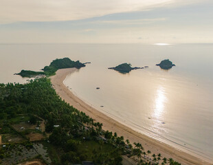 Stunning aerial view of Nacpan Beach’s winding shore, vibrant tropical greenery, and sparkling clear sea in El Nido, Palawan, Philippines
