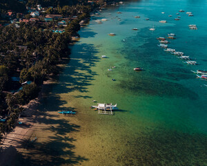 Bangka boats resting in Clear Skies and Peaceful Blue Horizon Over Coastal Paradise of El Nido’s Corong Corong Beach