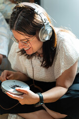 Young woman enjoying retro discman and headphones