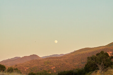 Full Moon Rising Over Mountain Ridge at Dusk

