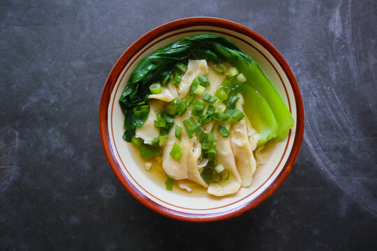 wonton soup or pangsit or dumplings soup and vegetable. wonton is traditional Chinese food of minced meat wrapped in flour sheets