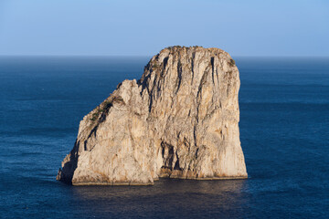 The azure waters near the iconic Faraglioni rocks off Capri Island during a clear day, showcasing Italy's stunning coastal beauty.