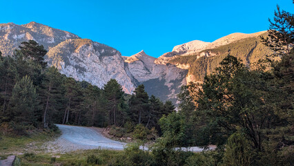 Village of Saravillo at sunset, with the golden rays of the sun illuminating its streets and houses, surrounded by the majestic mountains of the Chistau Valley, in the Aragon Pyrenees.
