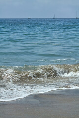 Ocean Waves Breaking on Sandy Beach under Blue Sky
