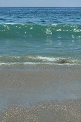 Ocean Waves Breaking on Sandy Beach under Blue Sky
