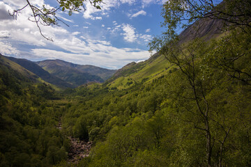 Spectacular mountain view at the popular hiking trail to the Steall Waterfall in the Nevis Gorge at the famous Glen Coe valley in Scotland.