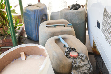 Close up shot of an old, dusty blue plastic container or gallon jug.