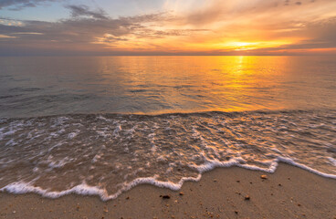 Sunset sky background over sea sand beach in the morning, Sunrise orange sun sky clouds in golden hour, Horizon landscape beautiful yellow sunny seaside summer
