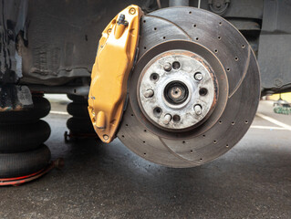 Automotive brake system featuring a yellow caliper and disc brake rotor