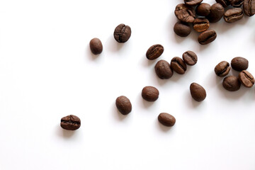 Roasted coffee beans are scattered on the table. White background.