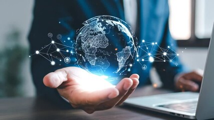 A hand holds a holographic representation of the globe, connected by a network of lines and points, above a laptop - Powered by Adobe