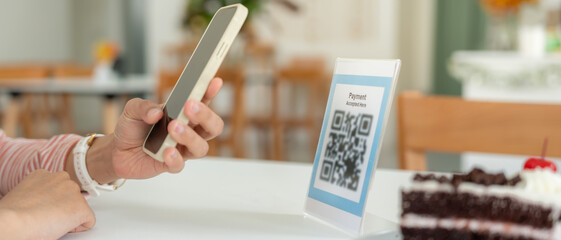 Woman use smartphone to scan QR code for order menu in cafe restaurant with a digital delivery....