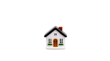 Small ceramic house figurine with white exterior, black roof, and brown door, symbolizing home and comfort. It features tiny windows and green shrub details, perfect for decoration