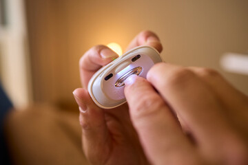 Close-up of an electric nail clipper in hand, modern personal care technology, highlighting compact...