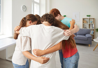 School children group in common hug, pre-teens, teenagers diverse friends embrace greeting in...