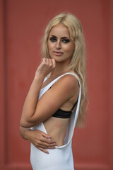 Portrait of a young beautiful blonde girl in a white tunic outdoors.