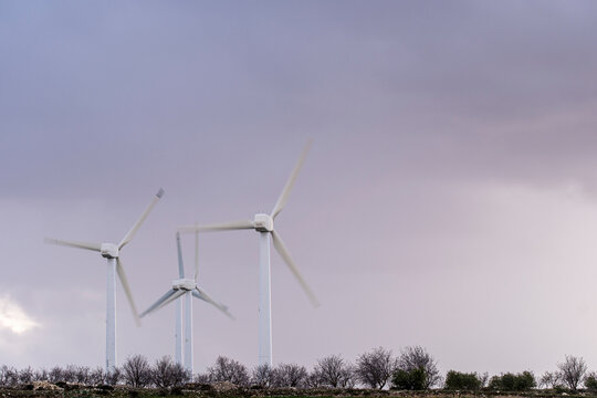 Cluster of wind turbines in a wintery field in Aragón, Spain, under cloudy sky, illustrating the resilience and scalability of renewable wind energy systems