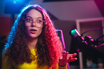 Popular blogger in a vibrant and modern studio setting using streaming equipment for an online...