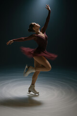 A graceful figure skater performs an elegant spin on the ice under soft lighting.