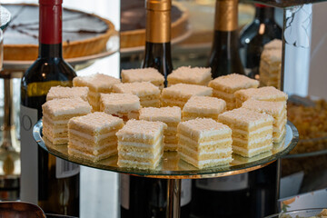 Photo of classic Napoleon cake cut into square pieces. The layered pastry with creamy filling and...