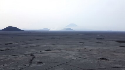 Dark Volcanic Plain Under Overcast Sky
