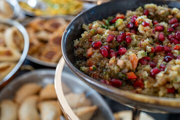 Photo of a traditional Lebanese dish featuring creamy hummus topped with fresh pomegranate seeds. The vibrant presentation highlights the blend of smooth texture and tangy fruit, showcasing authentic 