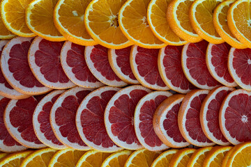Photo of sliced oranges and grapefruits arranged in a restaurant setting. The vibrant citrus fruit...