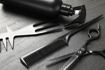 Different barber's tools on black table, closeup