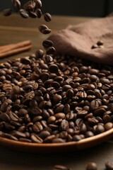 Pouring coffee beans onto plate at table, closeup