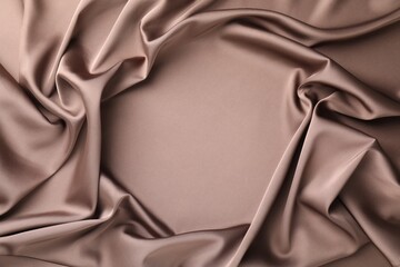 Crumpled light brown silk fabric as background, top view