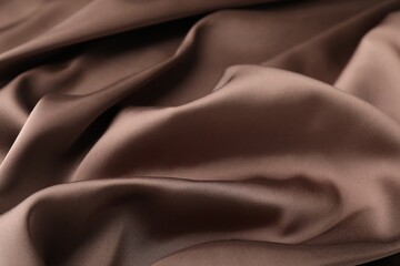 Crumpled light brown silk fabric as background, closeup