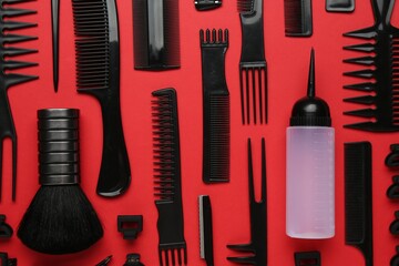 Different hairdresser's tools on red background, flat lay