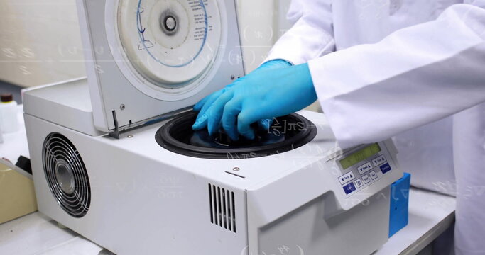 Technician wearing white lab coat loading sample tubes into benchtop centrifuge at lab bench - Powered by Adobe