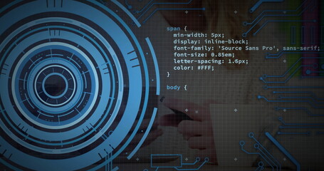 Holding smartphone with hands wearing long sleeves at desk showing CSS code over digital interface