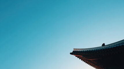 Fototapeta premium minimalist korean temple roof silhouette against cloudless blue sky