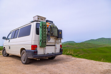 Van parked in rural landscape with outdoor adventure gear