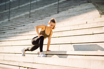 A sporty woman doing exercises outdoors at sunset. Beautiful woman in sportswear enjoying a workout...